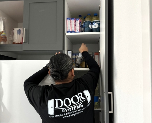 Audra Garcia, Door Systems volunteer stocking the pantry